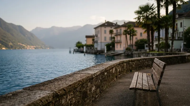 An empty bench on a lakeside promenade in a small Swiss town in early evening light